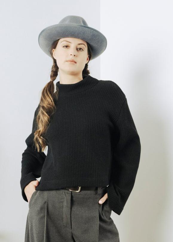 Black cropped knit top with long flared sleeves
Haut en tricot à couple ample et manches légèrement évasées